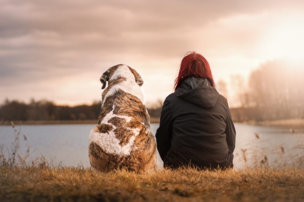 Dog sitting next to a woman