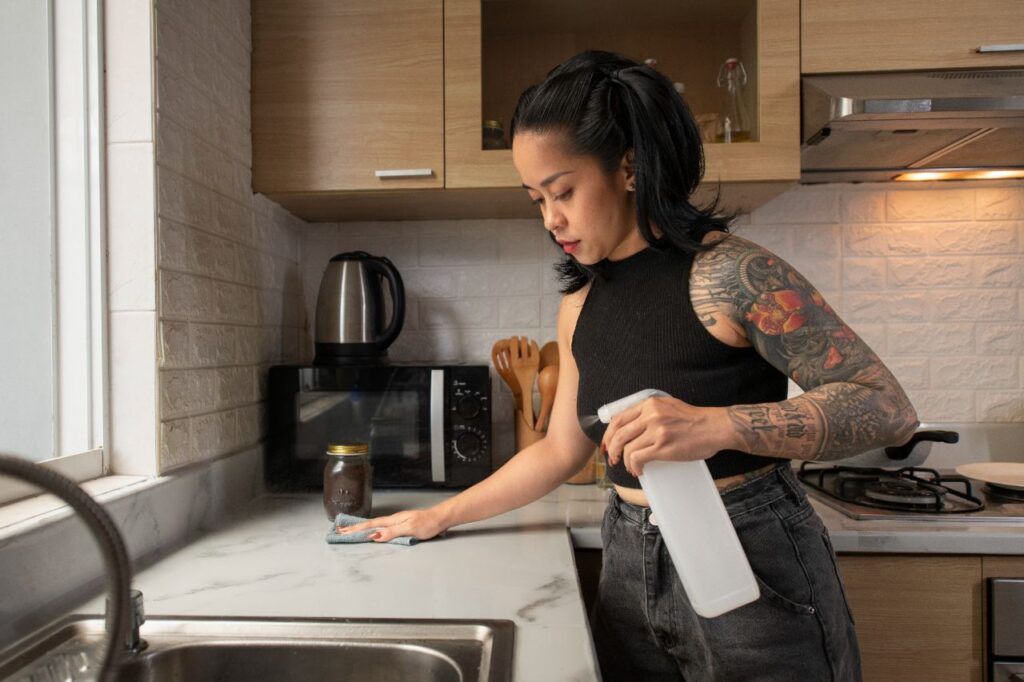 A woman cleaning kitchen countertop