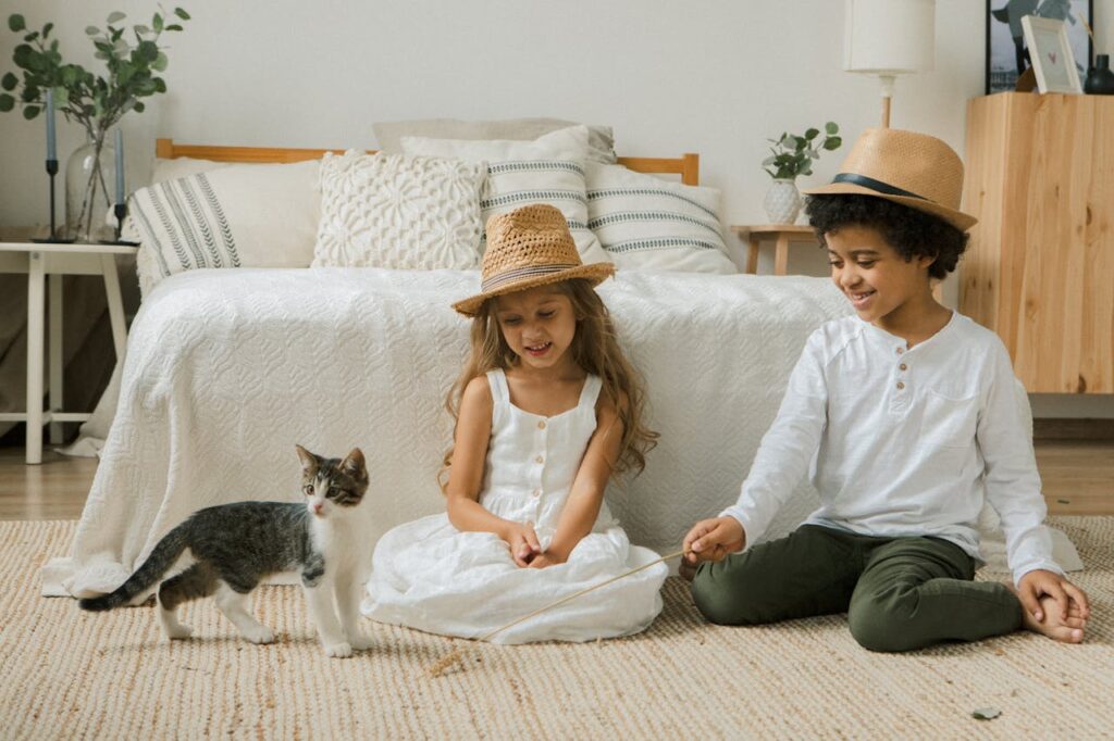 Kids playing with cat on floor