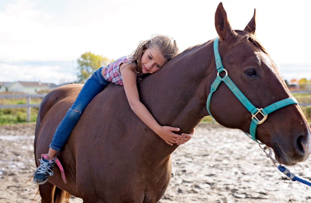 Kid hugging horse