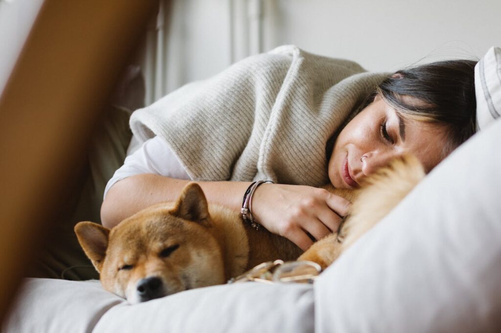 Dog sleeping on bed with female owner