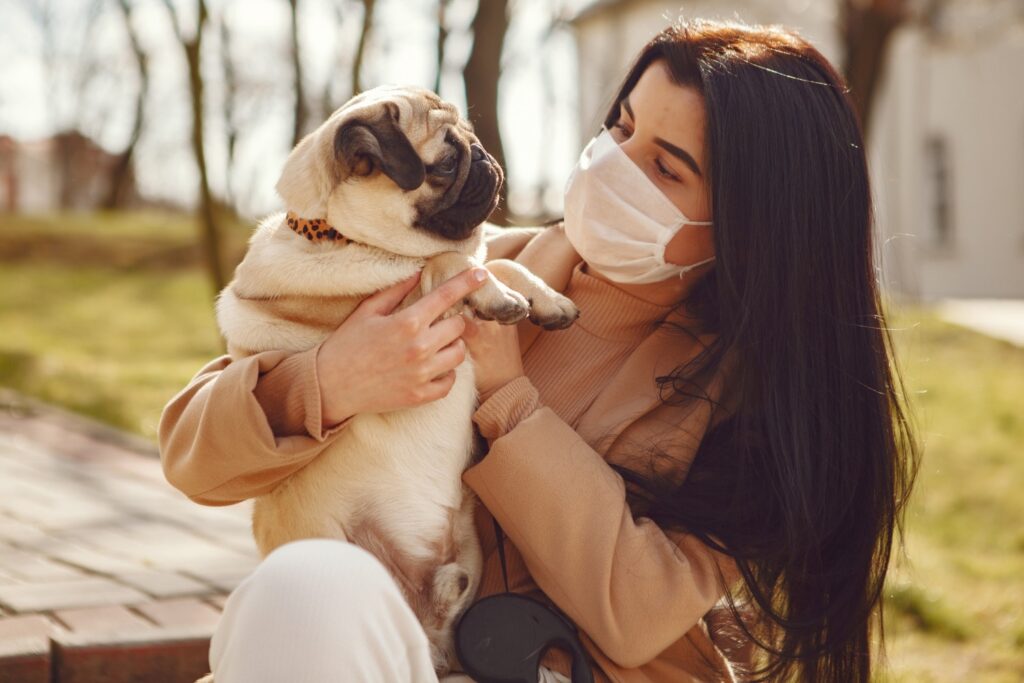 Woman in mask with pug