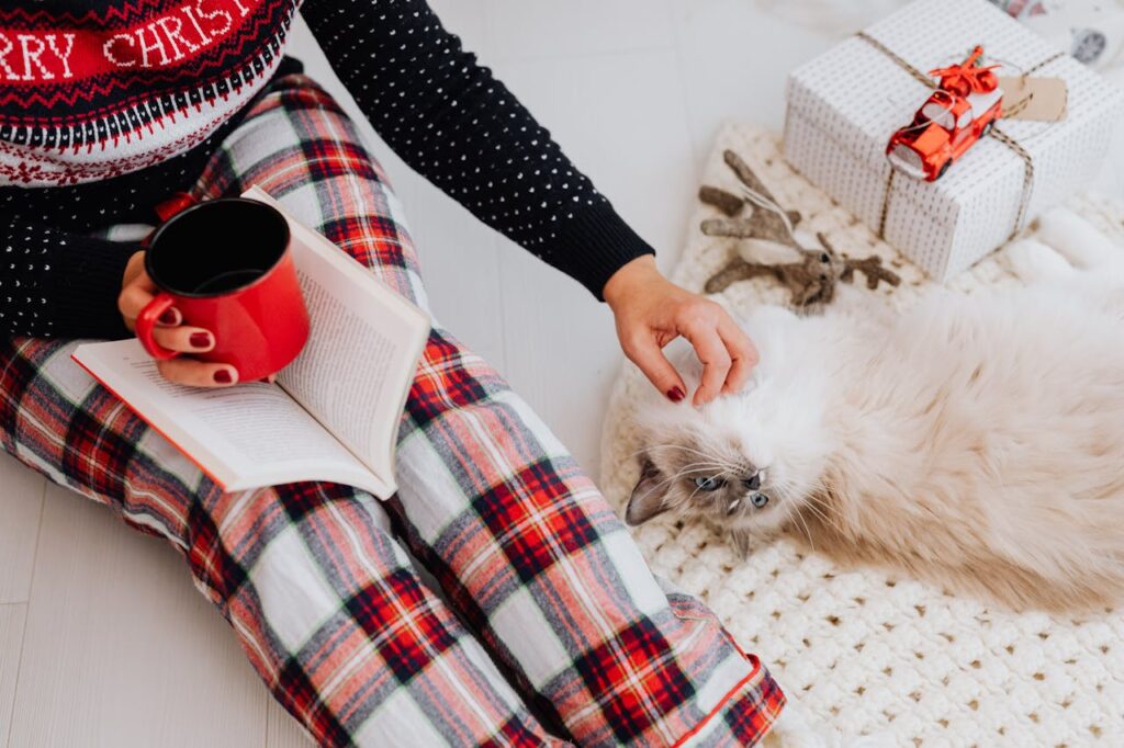A Woman Sitting on the Floor and Petting Her Ragdoll Cat
