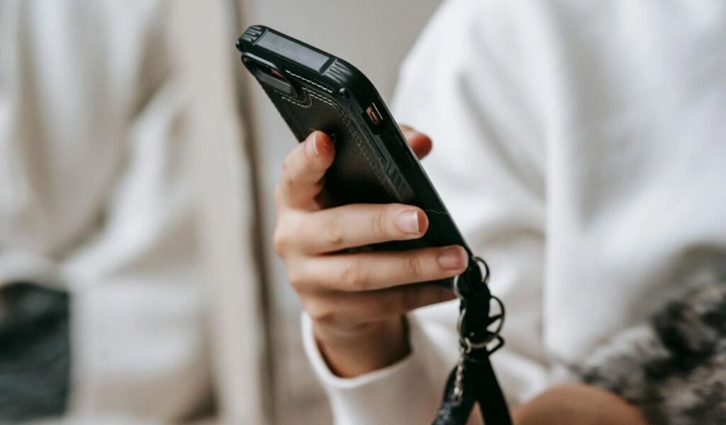 woman browsing smartphone in room