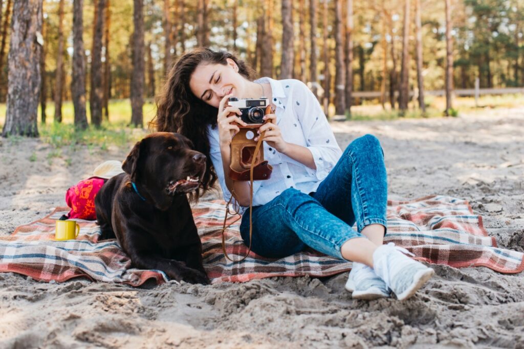 Woman sitting with her dog in nature spending time