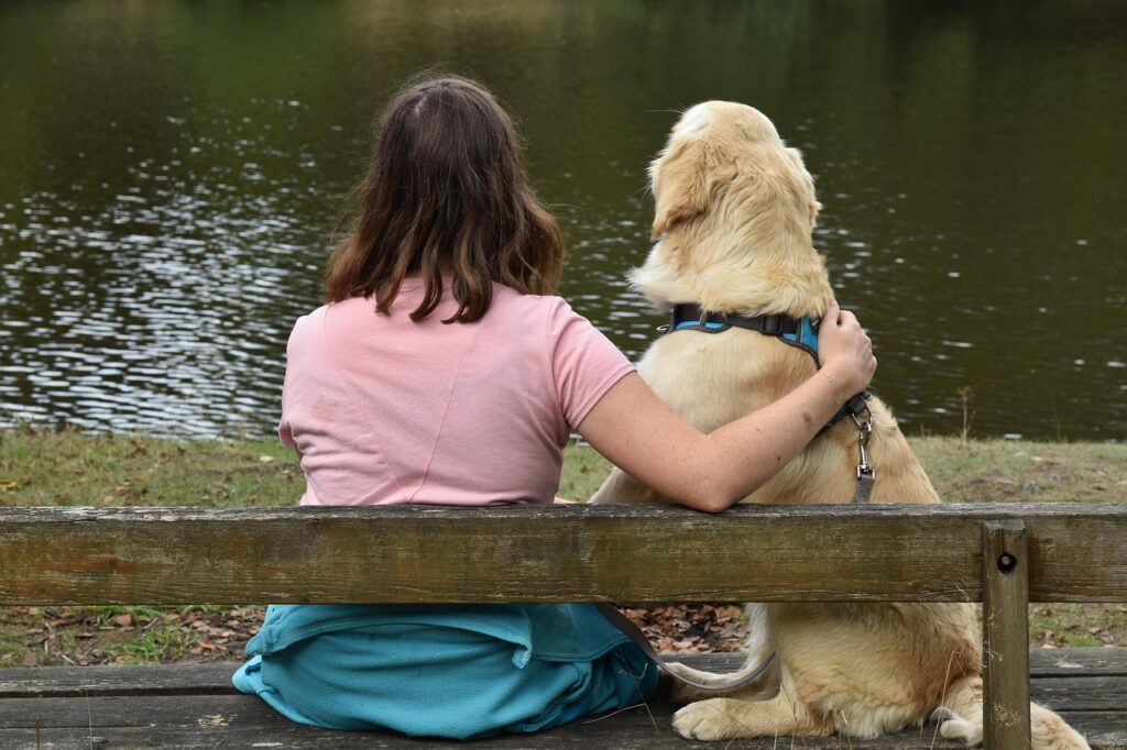 Woman with a Golden retriever by the lake