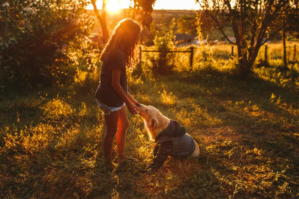 unrecognizable-woman-petting-dog-in-countryside
