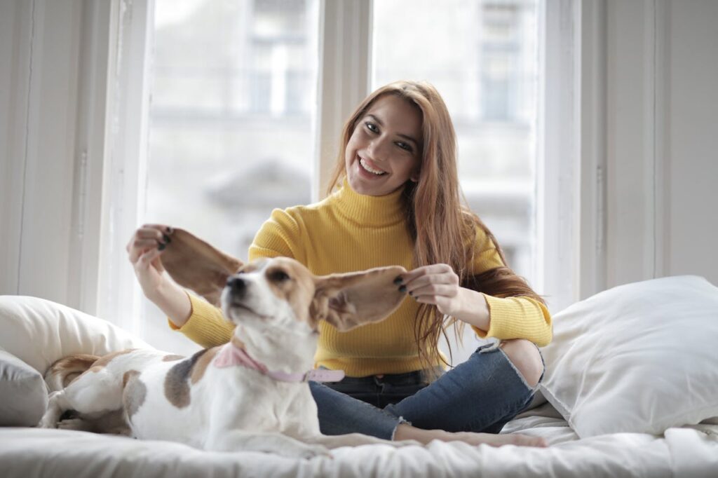 women pulling dogs ear