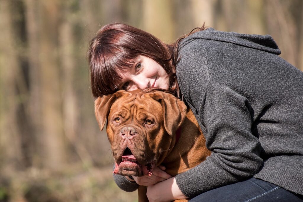 Women cuddle with dog